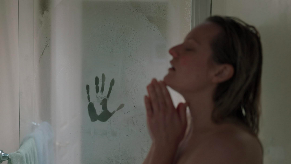 Elizbeth Moss sous la douche, avec une trace de main dans la buée, dans Invisible Man