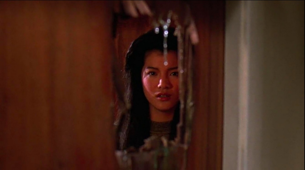 Kelly Hu regarde à travers un trou dans une porte